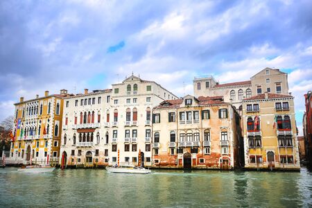 A view of boats sailing in the water canal in front of buildings in Venice, Italy.の写真素材