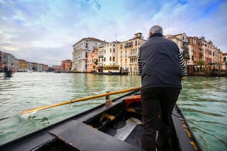 VENICE, ITALY - FEBRUARY 15 : A rear view of a gondolier in gondola sailing in the grand canal on February 15th, 2014 in Venice, Italy.のeditorial素材