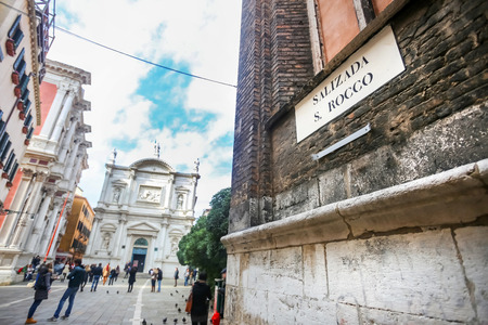 VENICE, ITALY - FEBRUARY 15 : Part of Frari Basilica with people walking in the square San Rocco in front of a renaissance palace called Scuola Grande di San Rocco on February 15th, 2014 in Venice, Italy.のeditorial素材