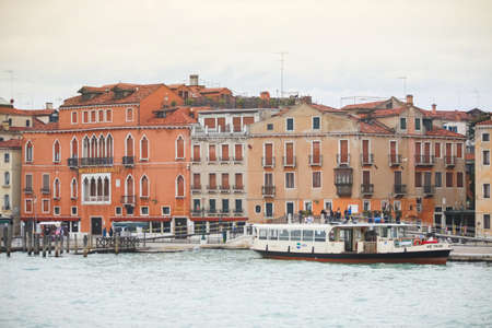 VENICE, ITALY - FEBRUARY 15 : A view of a passage boat next to the shore with people walking in the street on February 15th, 2014 in Venice, Italy.のeditorial素材