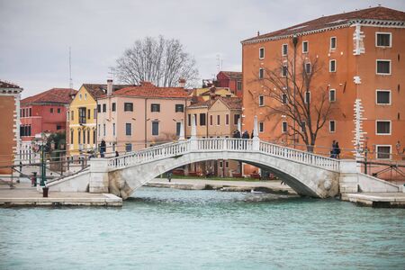 VENICE, ITALY - FEBRUARY 15 : A view of a water canal with people walking over the bridge on February 15th, 2014 in Venice, Italy.のeditorial素材