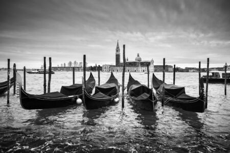 A view of the Church of San Giorgio Maggiore on the island of the San Giorgio Maggiore with gondolas parked in the water canal on Riva degli Schiavoni in Venice, Italy.の写真素材