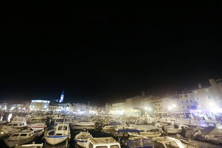 ROVINJ CROATIA  AUGUST 7 : A large group of boats anchored in the marina with a view of the city seafront at night on August 7th 2013 in Rovinj Croatia. Rovinj is a tourist destination on Adriatic coast of Croatia.のeditorial素材