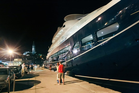 ROVINJ CROATIA  AUGUST 5 : People walking on the dock and sightseeing an anchored luxurious yacht Carinthia VII in the marina at night on August 5th 2011 in Rovinj Croatia.のeditorial素材