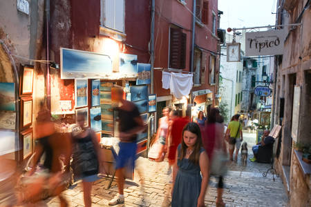 ROVINJ CROATIA  JULY 18 : People walking in the street next to souvenir shops and sightseeing the souvenirs displayed on the walls of the buildings on July 18th 2014 in Rovinj Croatia. Rovinj is a tourist destination on Adriatic coast of Croatia.のeditorial素材