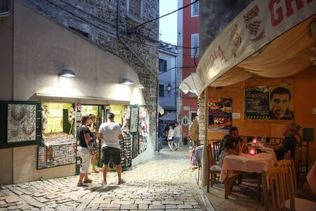 ROVINJ CROATIA  JULY 18 : People walking in the street next to the souvenir shops and a restaurant on July 18th 2014 in Rovinj Croatia. Rovinj is a tourist destination on Adriatic coast of Croatia.のeditorial素材