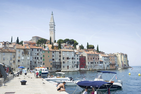 ROVINJ CROATIA  JULY 20 : A view of the old city core with people and boats moored at the dock on July 20th 2014 in Rovinj Croatia. Rovinj is a popular tourist destination on the Adriatic coast in Croatia.のeditorial素材
