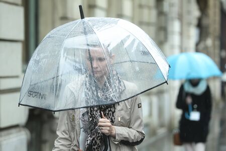 ZAGREB CROATIA  MAY 22 : A rainy and windy weather on the street of the city center on May 22 2015 in Zagreb Croatia. A close up of a woman with umbrella.のeditorial素材