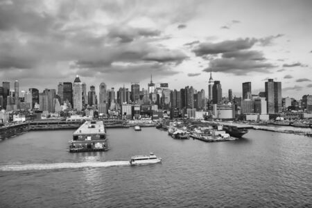 NEW YORK CITY, USA - MARCH 9 : The cityscape of Midtown Manhattan and the Intrepid Museum viewed from the Hudson River at sunset on March 9th, 2005 in New York City, USA.のeditorial素材