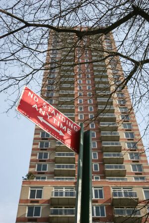 A low angle view of a street sign and a skyscraper in Midtown Manhattan in New York City, USA.のeditorial素材