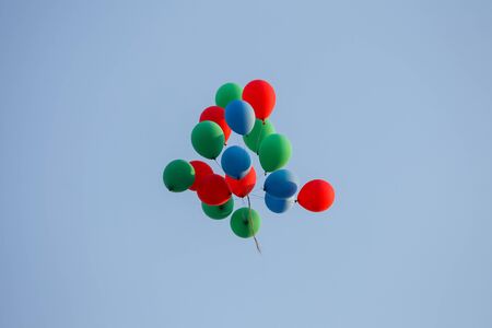 A view from below of a group of colorful balloons flying in the air.の写真素材