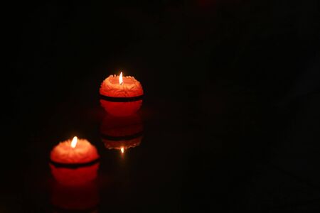 Two round candles lighting in the dark.の写真素材