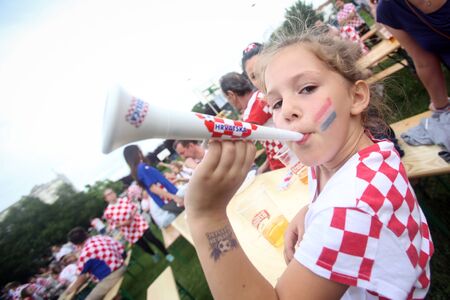 ZAGREB, CROATIA - JUNE 17, 2016 : Croatian football fans on the playground at Jarun, watching EURO 2016 match Czech Republic vs Croatia in Zagreb, Croatia. Girl cheers with a small horn.のeditorial素材