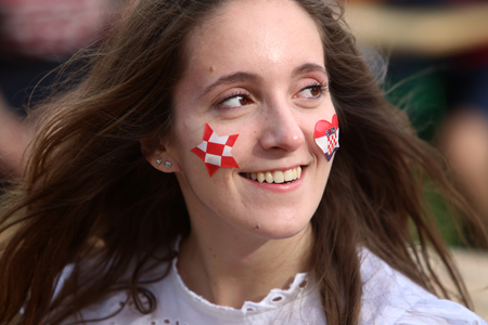 ZAGREB, CROATIA - JUNE 17, 2016 : Croatian football fans on the playground at Jarun, watching EURO 2016 match Czech Republic vs Croatia in Zagreb, Croatia. Close up of girl with Croatian national characteristics on her face.のeditorial素材