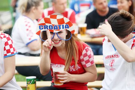 ZAGREB, CROATIA - JUNE 17, 2016 : Croatian football fans on the playground at Jarun, watching EURO 2016 match Czech Republic vs Croatia in Zagreb, Croatia. Cheerful girl with funny croatian glasses.のeditorial素材