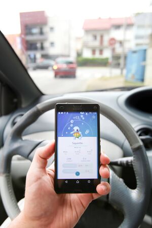 VELIKA GORICA, CROATIA- JULY 15, 2016 : A gamer using a smartphone to play Pokemon Go while driving...