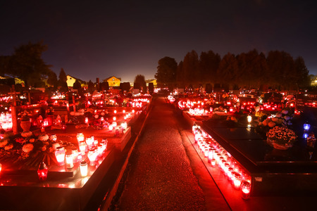 VELIKA GORICA, CROATIA - NOVEMBER 1, 2016 : A night view of ornated graves with flowers and burning lampions at cemetery on All Saints day in Velika Gorica, Croatia.のeditorial素材