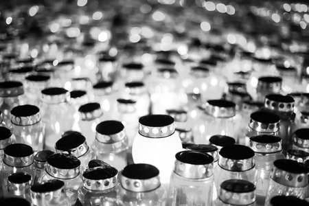 A night view of hundreds of candles lit for the deceased family members and friends lined up on the floor at cemetery on All Saints day.の写真素材