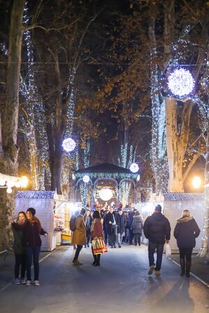 ZAGREB, CROATIA - DECEMBER 1th, 2016: Advent time in city center of Zagreb, Croatia. People gathering in the Zrinjevac park ornate with food stands and illuminating trees.のeditorial素材