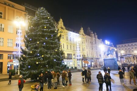 ZAGREB, CROATIA - DECEMBER 1th, 2016: Advent time in city center of Zagreb, Croatia. People on central Jelacic square with a large ornated pine tree.のeditorial素材