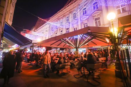 ZAGREB, CROATIA - DECEMBER 1th, 2016: Advent time in city center of Zagreb, Croatia. People sitting in coffee shops in ornated Bogoviceva street.のeditorial素材