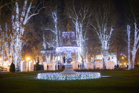 ZAGREB, CROATIA - DECEMBER 1th, 2016: Advent time in city center of Zagreb, Croatia. The illuminating trees and water fountain in the ornate Zrinjevac park.のeditorial素材