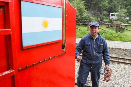 USHUAIA, ARGENTINA - FEBRUARY 2, 2006 : A railway employee standing at the station next to The Train of the End of the World in Ushuaia, Argentina. The Southern Fuegian Railway is the southernmost functioning railway in the world.のeditorial素材