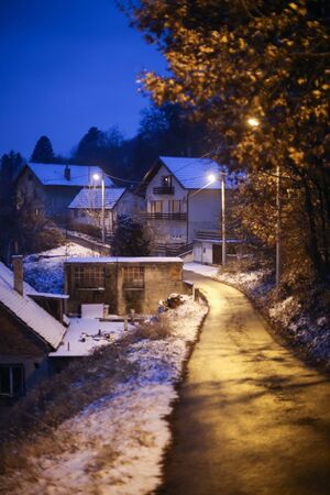 A view of houses in village covered in snow at sunset.の写真素材