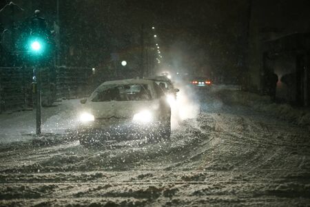 VELIKA GORICA, CROATIA - JANUARY 13th, 2017 : Cars passing through the green traffic light at the intersection of roads in the aggravated traffic due to strong snowfall in Velika Gorica, Croatia.のeditorial素材