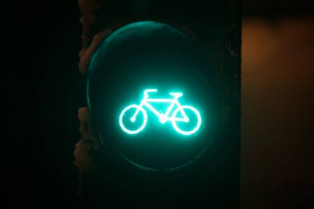 A close up of scoreboad showing green light for bicycles during snowfall.の写真素材