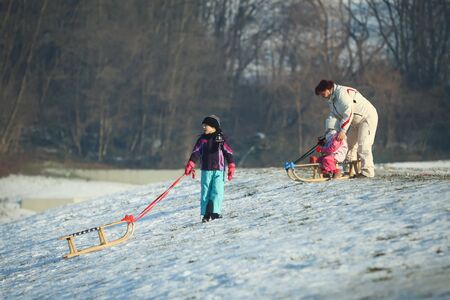 ZAGREB, CROATIA - JANUARY 15, 2017 : Children sledding down the hill in the presence of an adult woman at winter time in Zagreb, Croatia.のeditorial素材