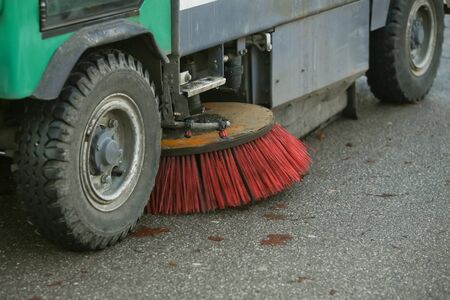 A close up of wheels and brush of a street sweeper machine.の写真素材