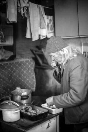 An old man preparing pork meat for cooking.の写真素材