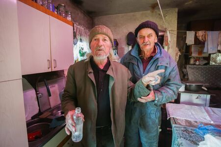 Portrait of two old men standing in the kitchen.の写真素材