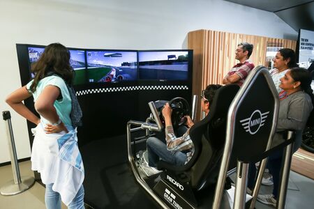 MUNICH, GERMANY - MAY 6, 2017 : People trying out the BMW car driving simulator in the BMW Welt...