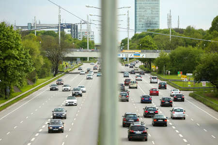 MUNICH, GERMANY - MAY 6, 2017 : The traffic on Georg Brauchle Ring highway with the Munich Uptown Building in the background in Munich, Germany.のeditorial素材