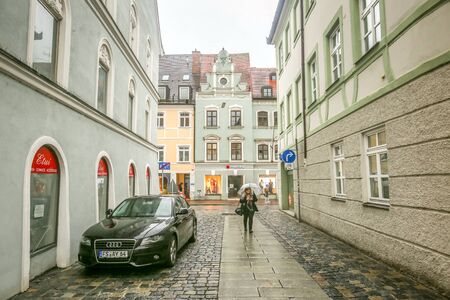 FREISING, GERMANY - MAY 8, 2017: Traditional german architecture with a woman walking in the street...
