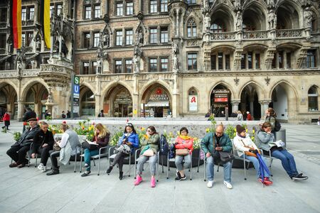 MUNICH, GERMANY - MAY 9, 2017 : People resting on chairs in front of New Town Hall at Marienplatz in Munich, Germany.のeditorial素材