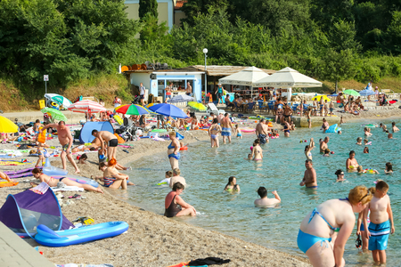 NJIVICE, CROATIA - JUNE 24, 2017 : People bathing and sunbathing on sea beach in Njivice, Croatia.のeditorial素材
