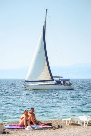 NJIVICE, CROATIA - JUNE 24, 2017 : A sailboat sailing next to the beach in Njivice, island Krk, Croatia.のeditorial素材