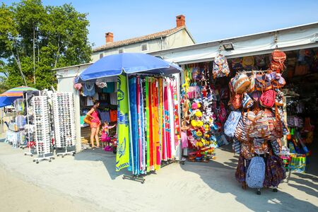 NJIVICE, CROATIA - JUNE 24, 2017 : People visiting a clothes and accessory shop at waterfront  in Njivice, island of Krk, Croatia.のeditorial素材