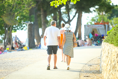 Senior couple walking on the beach and holding hands in Njivice, island of Krk, Croatia.の写真素材