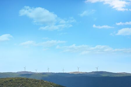 A group of windmills lined up on a hill in Croatia.