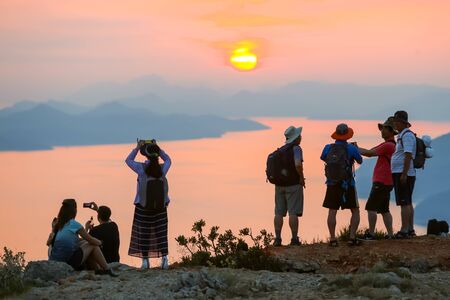DUBROVNIK, CROATIA - JULY 21, 2017 : Tourists on Srd mountain sightseeing the ancient old town and Elafiti islands at sunset in Dubrovnik, Croatia.のeditorial素材