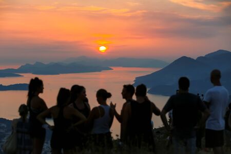 DUBROVNIK, CROATIA - JULY 21, 2017 : Tourists on Srd mountain sightseeing the ancient old town and Elafiti islands at sunset in Dubrovnik, Croatia.のeditorial素材