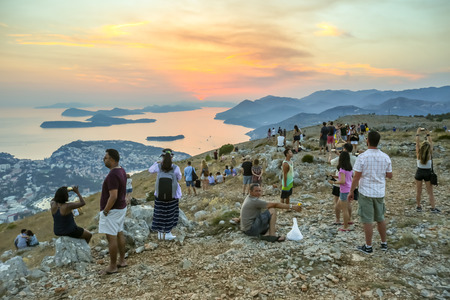 DUBROVNIK, CROATIA - JULY 21, 2017 : Tourists on Srd mountain sightseeing the ancient old town and Elafiti islands at sunset in Dubrovnik, Croatia.のeditorial素材