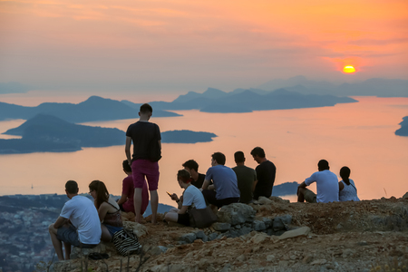DUBROVNIK, CROATIA - JULY 21, 2017 : Tourists on Srd mountain sightseeing the ancient old town and Elafiti islands at sunset in Dubrovnik, Croatia.のeditorial素材