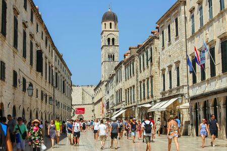 DUBROVNIK, CROATIA - JULY 23, 2017 : People walking down the Stradun, the main city street with the bell tower of Franciscan monastery in the background in Dubrovnik, Croatia.のeditorial素材