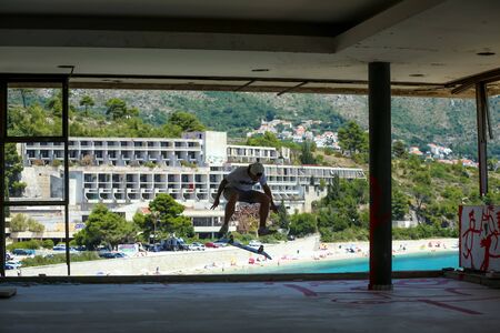 KUPARI, CROATIA - JULY 18, 2017 : A young man skateboarding in an hotel in abandoned Yugoslavian military resort in Kupari, Croatia.のeditorial素材