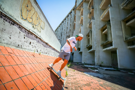 KUPARI, CROATIA - JULY 18, 2017 : A young man skateboarding in an hotel in abandoned Yugoslavian military resort in Kupari, Croatia.のeditorial素材